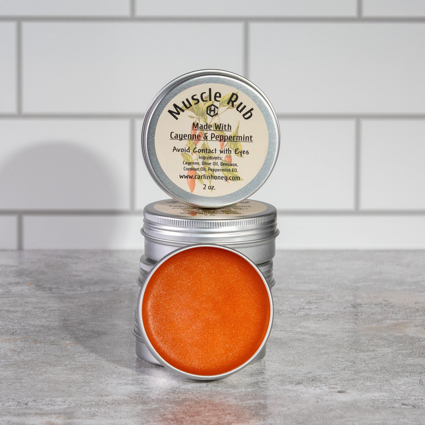 Tin of Muscle Rub with visible label on a wooden surface against a tiled wall background