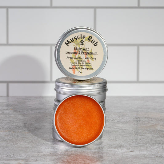 Tin of Muscle Rub with visible label on a wooden surface against a tiled wall background