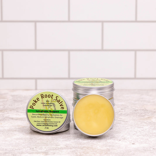 Two containers of poke root salve on a white tiled surface