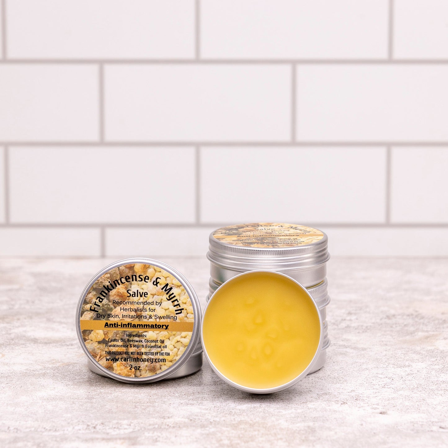 Two metal containers with a yellow substance on a white tiled surface